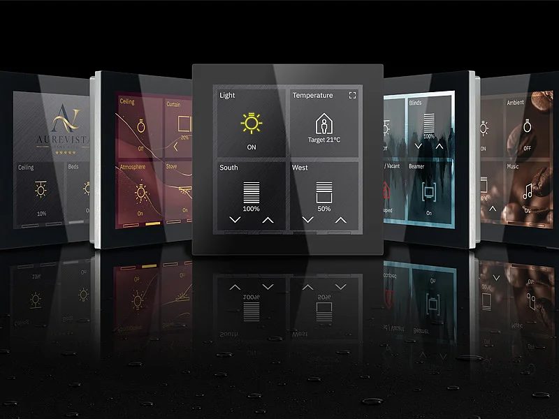 Mehrere KNX-Bedienpanels mit Glasfront in verschiedenen Farben und Designs, nebeneinander aufgereiht